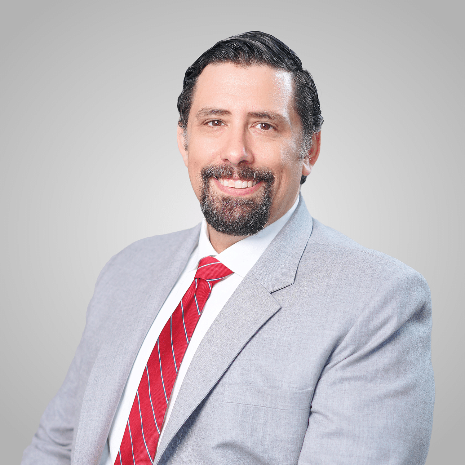 Sturgis-Square Smiling man in gray suit and red striped tie