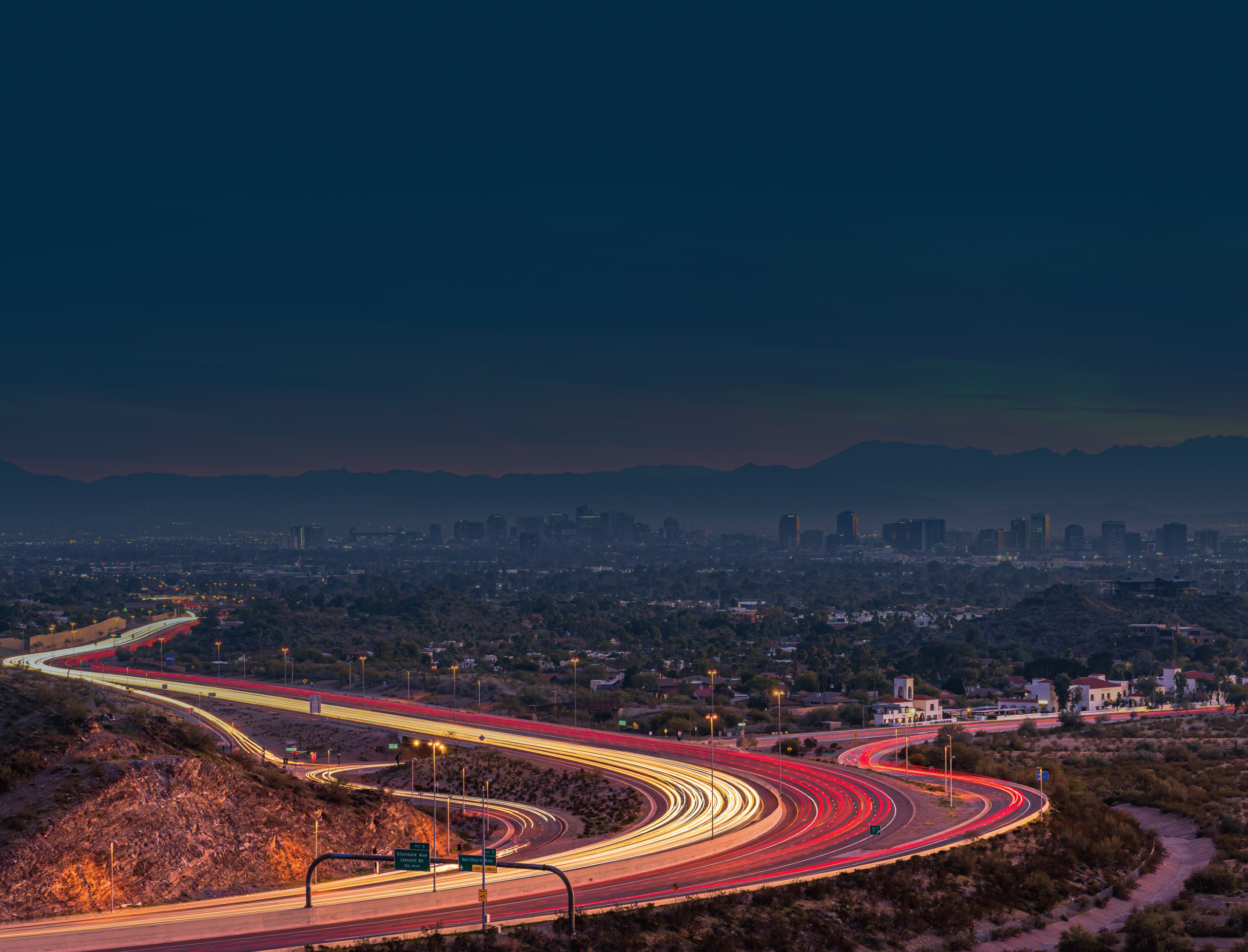 City skyline and busy highway at night.