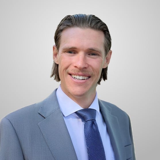 kahl-update Smiling man in a gray suit and blue tie.